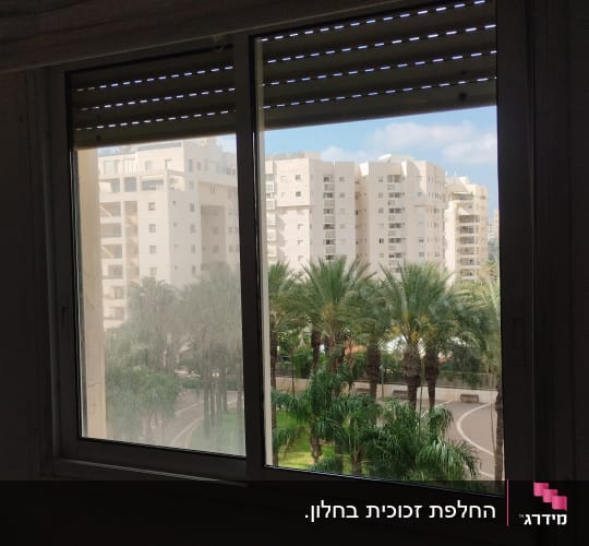 תריסים חומים פתוחים חלקית בחלון זכוכית